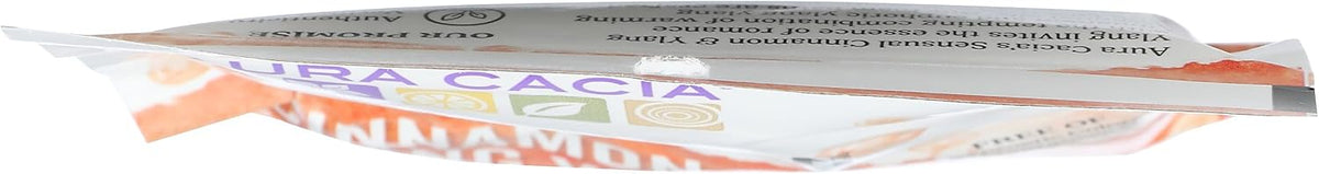 Aura Cacia cinnamon ylang ylang pouch displayed with botanical ingredients