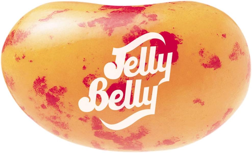 Jelly Belly gourmet peach flavored jelly beans poured out showcasing vibrant orange color.