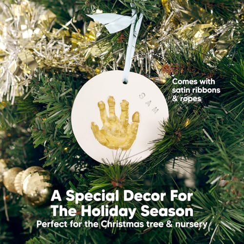 Completed personalized baby handprint ornament with gold paint highlights hanging on a holiday tree