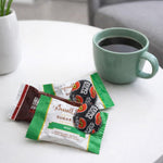 Assorted individually wrapped dark chocolate candies pile.