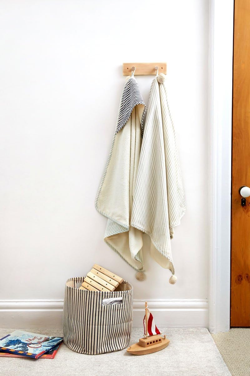 Close up of the playful pom-pom trim on the Pehr striped baby towel hood