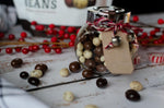 Gourmet chocolate covered coffee beans spilled next to the sixteen ounce package