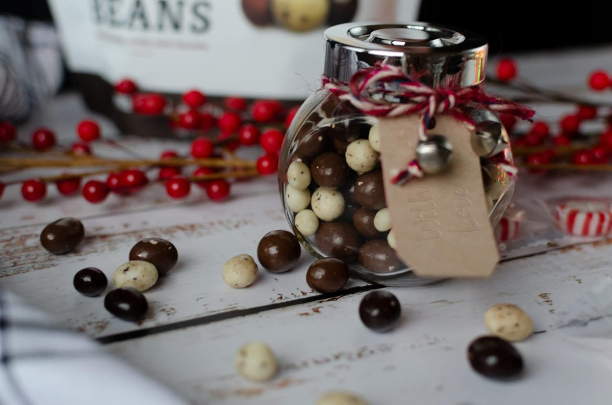 Gourmet chocolate covered coffee beans spilled next to the sixteen ounce package