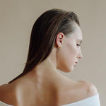 Silver stainless steel hoop earring angled to display its slim thickness.