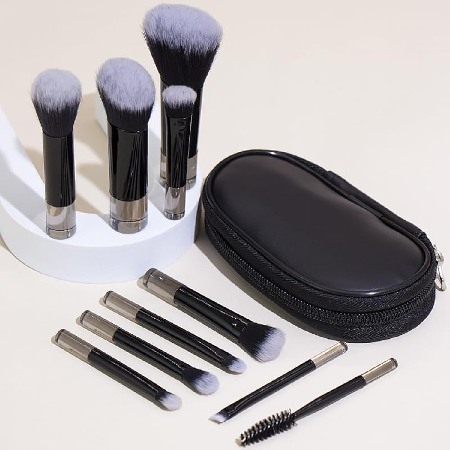 COSHINE portable on the go makeup brush set front view showing ten mini black brushes neatly arranged outside their matching travel pouch.