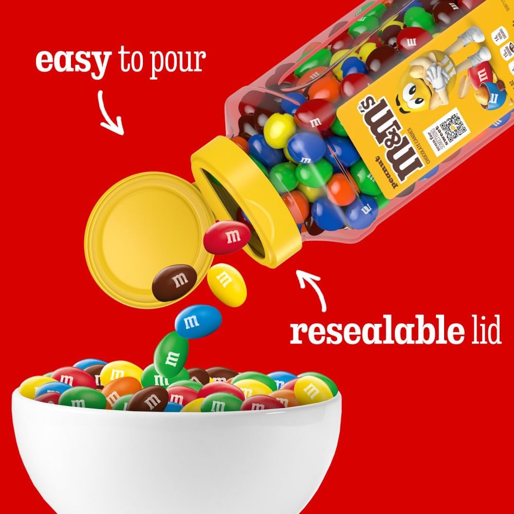 Two large twenty three ounce jars of peanut M&M's side by side on a clean kitchen counter