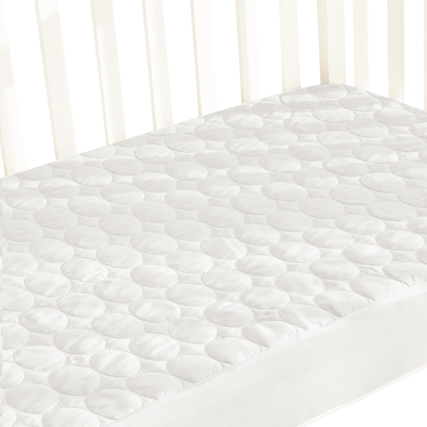 Biloban waterproof crib mattress protector pad front view on a baby bed