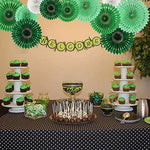 Vibrant birthday backdrop decoration featuring hanging round paper fans arranged nicely over a dessert table setup.