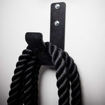 Wall mounted battle rope holder installed on a gym wall