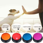 Multi colored talking buttons for dogs being pressed by a hand.