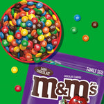 Vibrant and colorful dark chocolate M&M'S candies spilled out onto a table showcasing the crisp candy shells