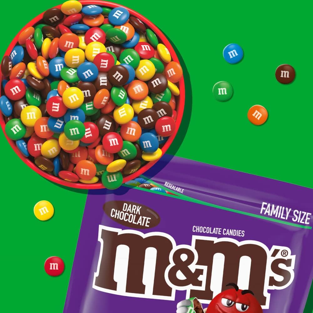 Vibrant and colorful dark chocolate M&M'S candies spilled out onto a table showcasing the crisp candy shells