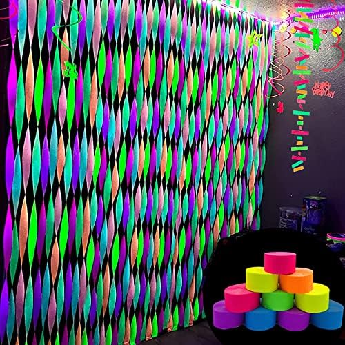 Blacklight reactive party supplies draped across a ceiling for a glowing birthday theme.