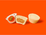 A handful of white creme Reese's miniatures illustrating the perfect pop-able size for party snacking.