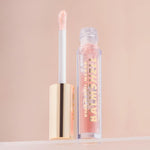 Milani lip plumper with jojoba oil showing the thick cushiony texture through the transparent tube