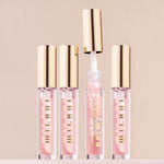 Milani high comfort volumizing lip balm placed upright on a clean reflective vanity surface