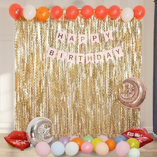 Trimming the length of a gold tinsel curtain with scissors for custom wall fit