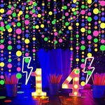 Six pieces of pre-assembled neon streamers hung across a party ceiling creating a fluorescent atmosphere.