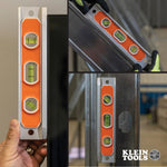 Klein Tools magnetic torpedo level resting on a metal junction box.