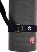Manduka cotton mat strap folded neatly on white background