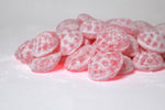 Assorted sour hard candies displayed in decorative tins