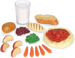 Learning Resources play food pieces arranged outside the shopping basket