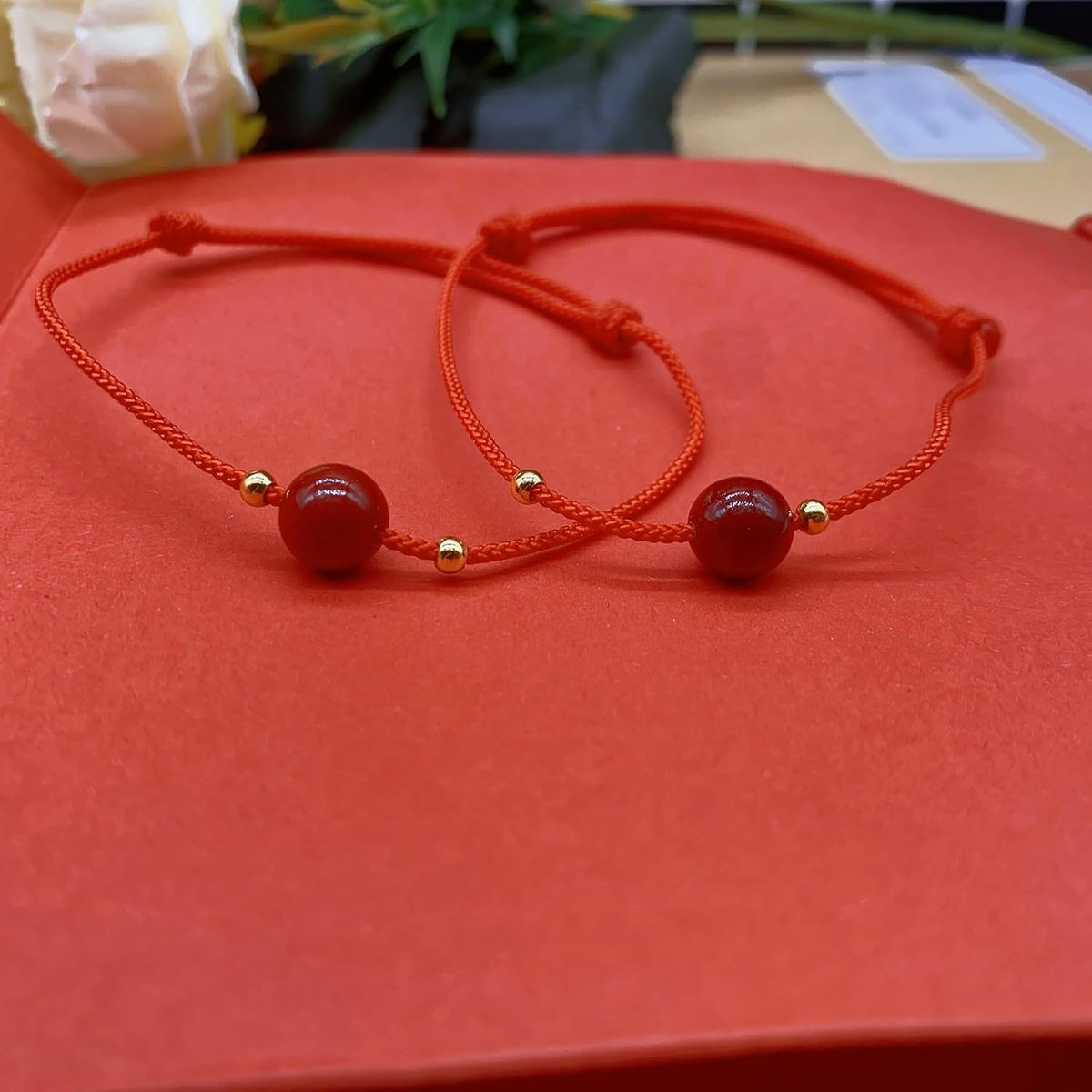 Model wrist wearing the ZMANYIJEW red string bracelet set