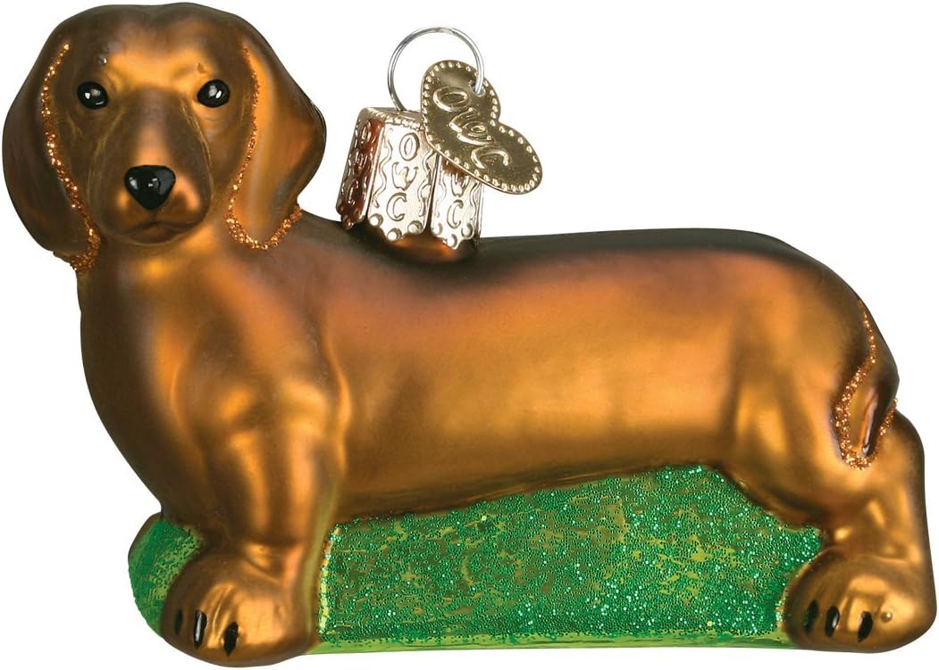Old World Christmas Chihuahua ornament resting on its sparkling green glitter base.