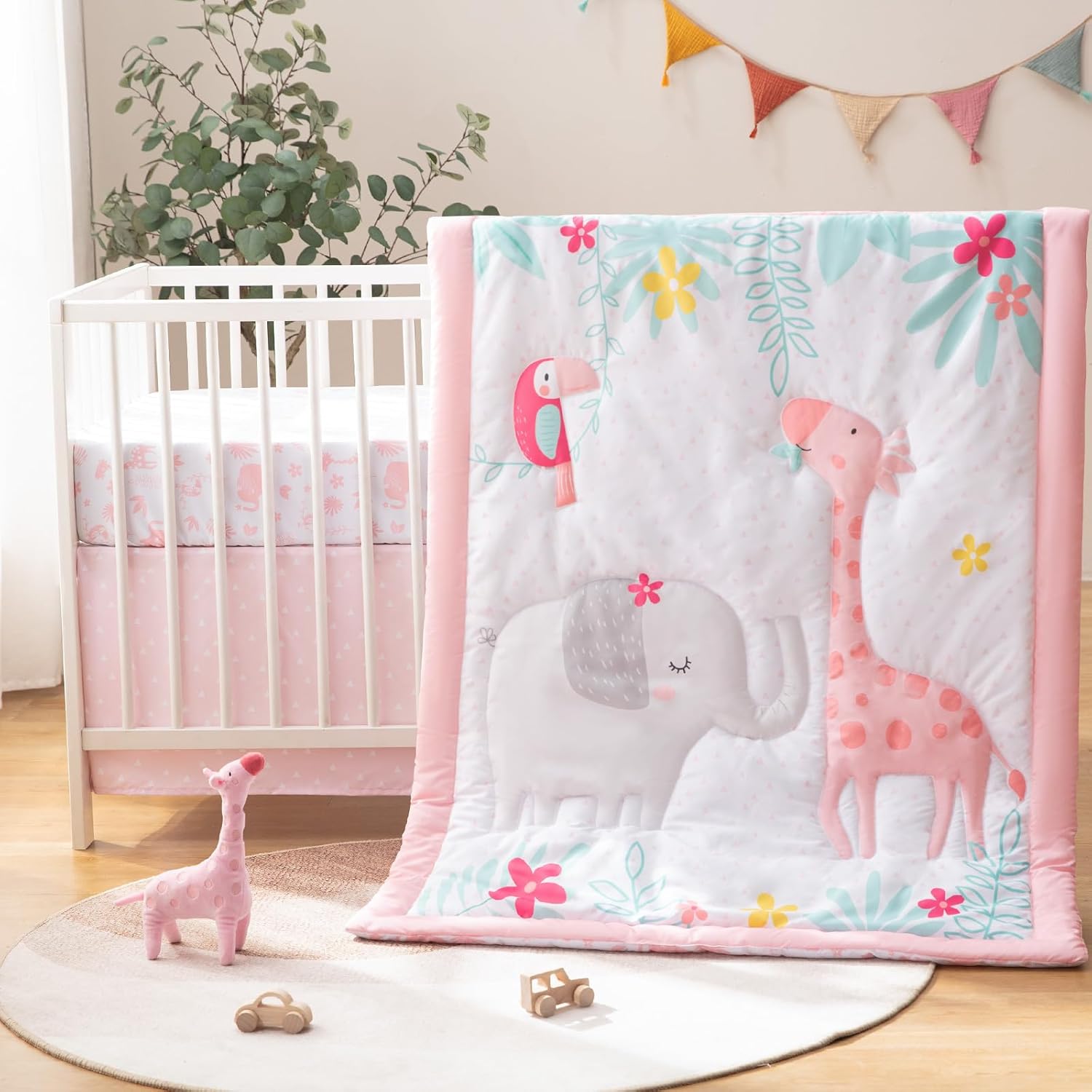 TCOYIWL 4 piece crib bedding set front view showcasing the reversible cartoon quilt and plush giraffe toy