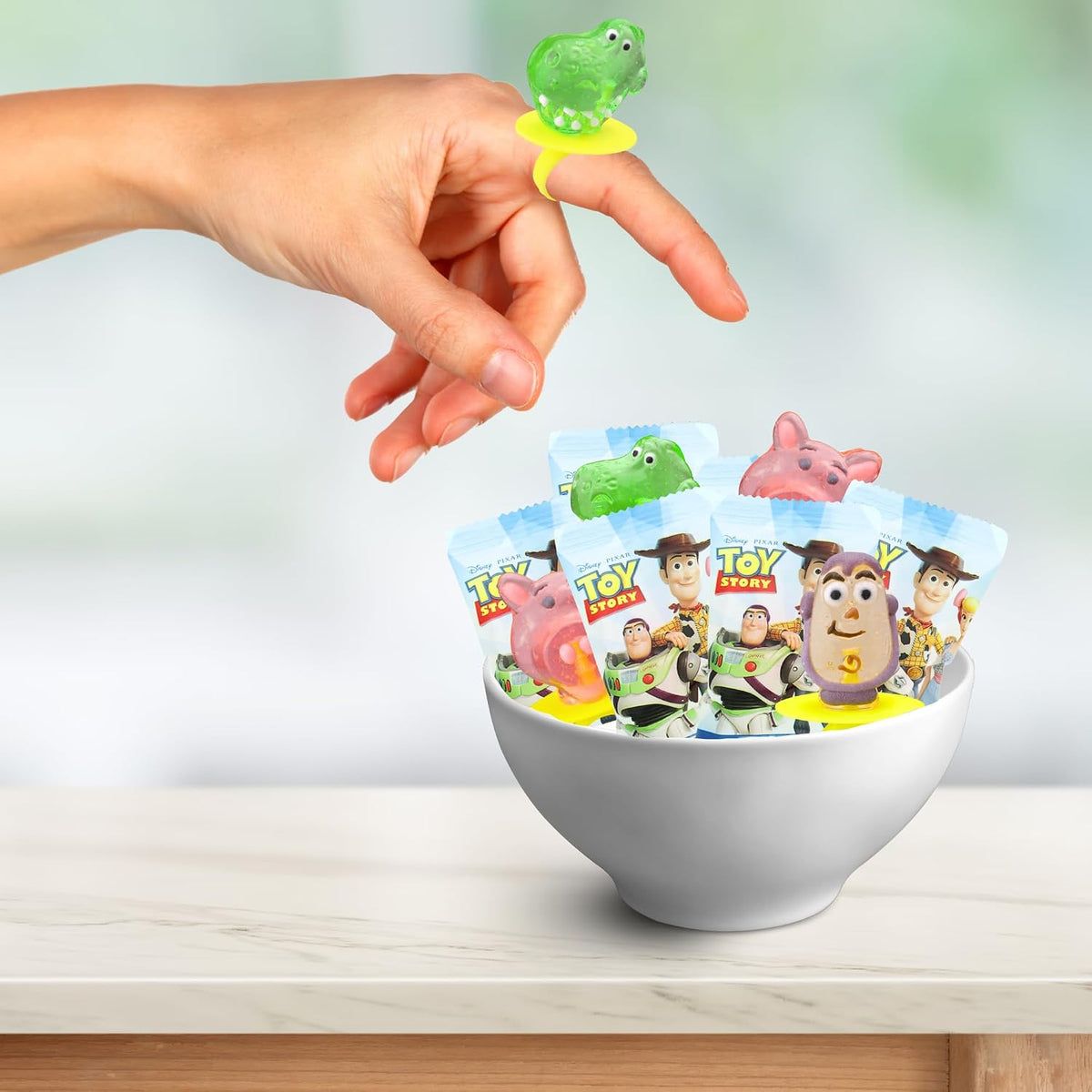 Assortment of Rex, Hamm, and Forky lollipop rings unwrapped to display the detailed hard candy molding.