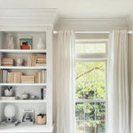 White window curtain rod installed with grommet drapes