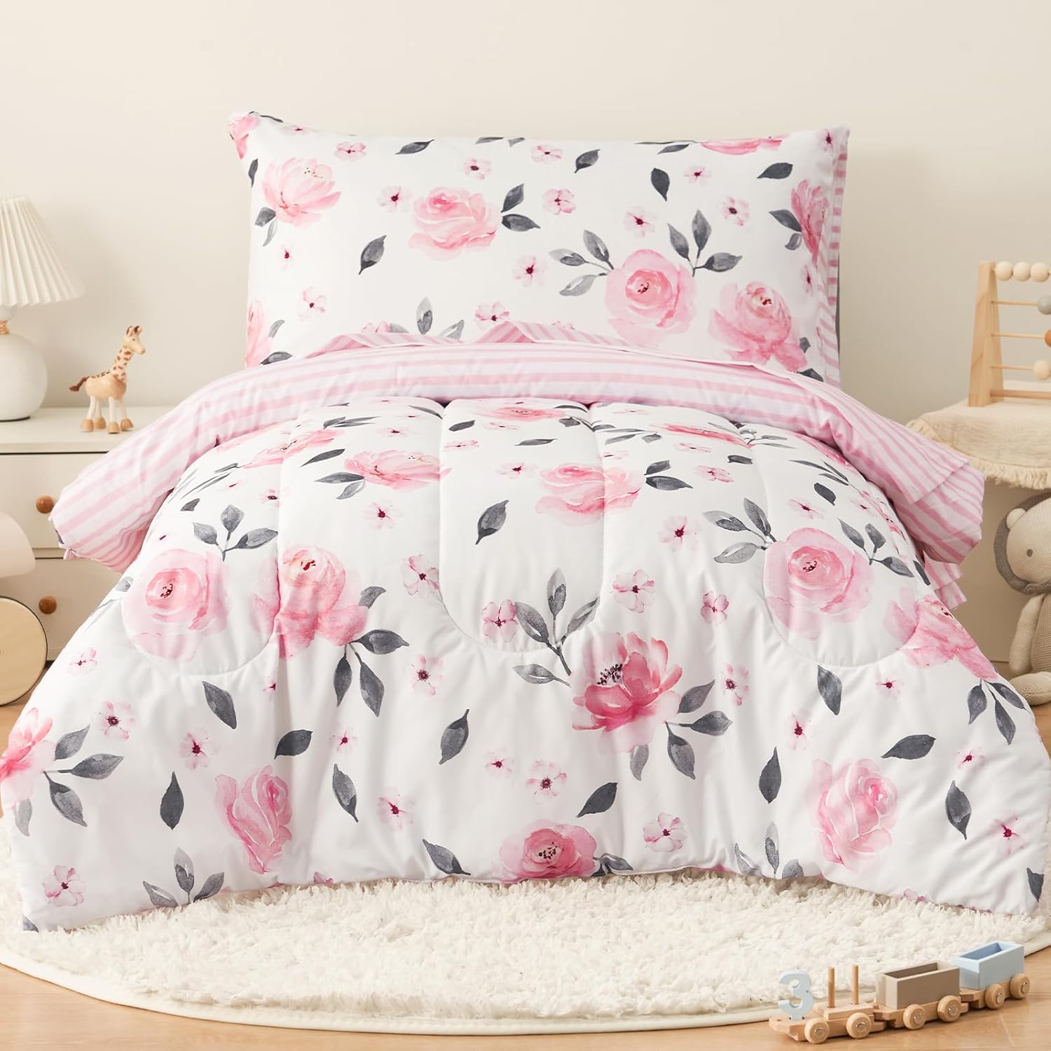 PHF 4 piece toddler bedding set front view showcasing the pink watercolor floral comforter on a white bed.