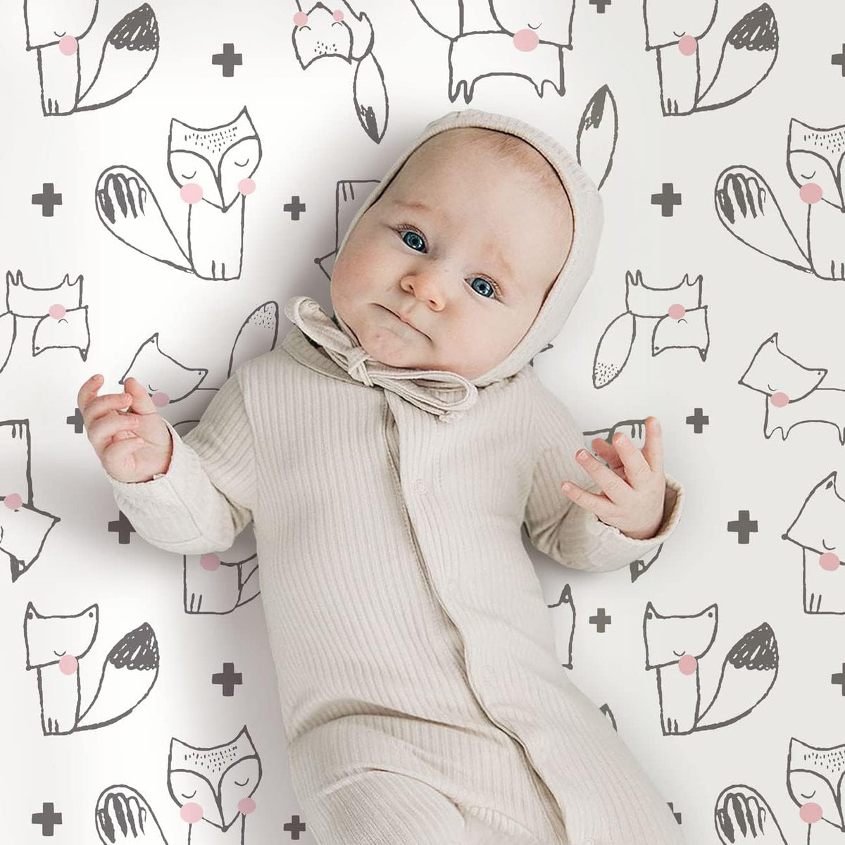 Baby resting comfortably on soft pink rabbit print mattress sheet