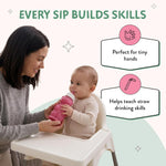 Toddler holding a pink raspberry sorbet colored honey bear drinking cup