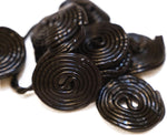 DM Sweets Black Licorice Wheels piled together highlighting the bulk quantity of forty pieces per pack.