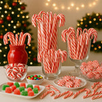 Traditional peppermint candy cane ornaments hanging elegantly from festive green branches.