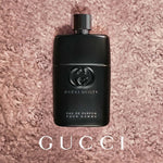 Close-up shot of the embossed Gucci interlocking G logo on the perfume bottle.