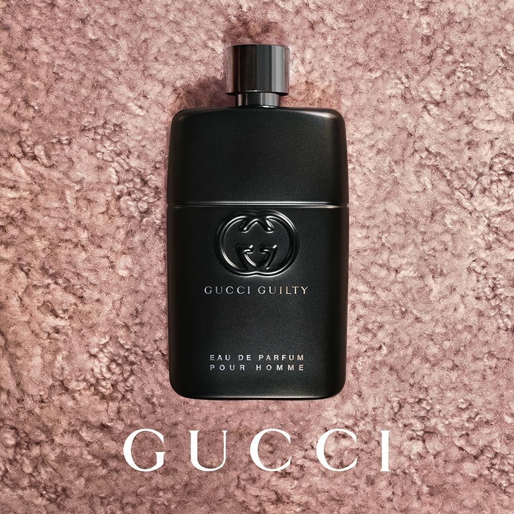 Close-up shot of the embossed Gucci interlocking G logo on the perfume bottle.