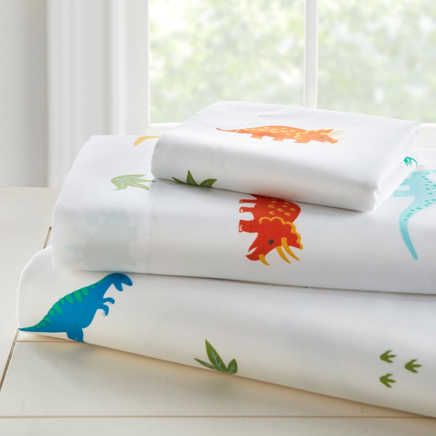 Wildkin toddler sheet set jurassic dinosaurs front view on bed