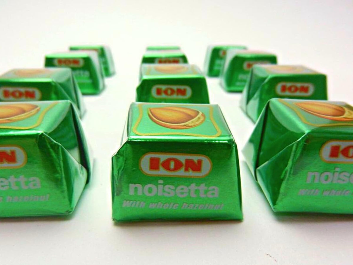 Bite-sized milk chocolate shell showing whole hazelnut inside