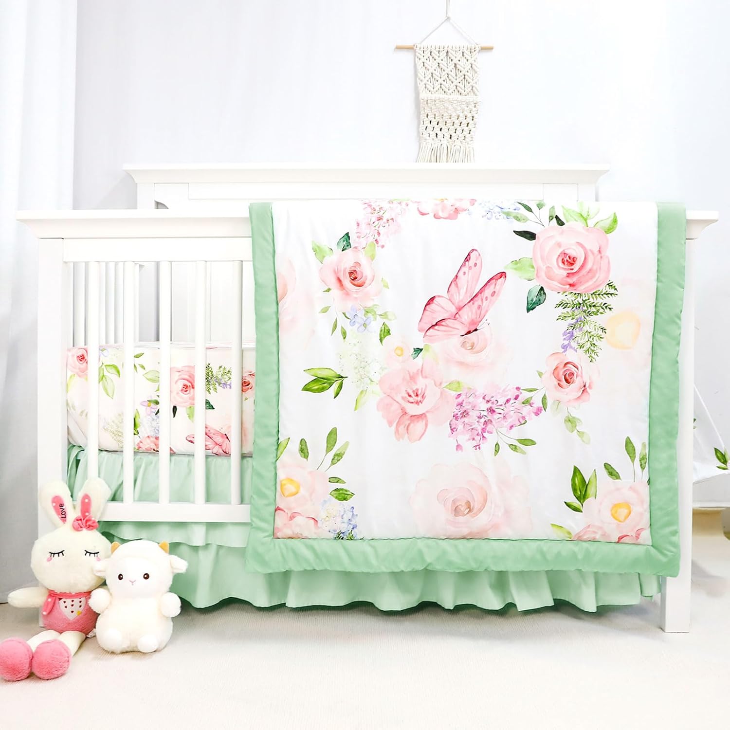 CARUILI 4-Piece Crib Bedding Set front view featuring a pink butterfly comforter and green ruffled skirt inside a white wooden nursery cot.