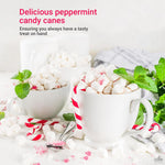 Individually wrapped mini peppermint candy canes spread out for Christmas party decorations.