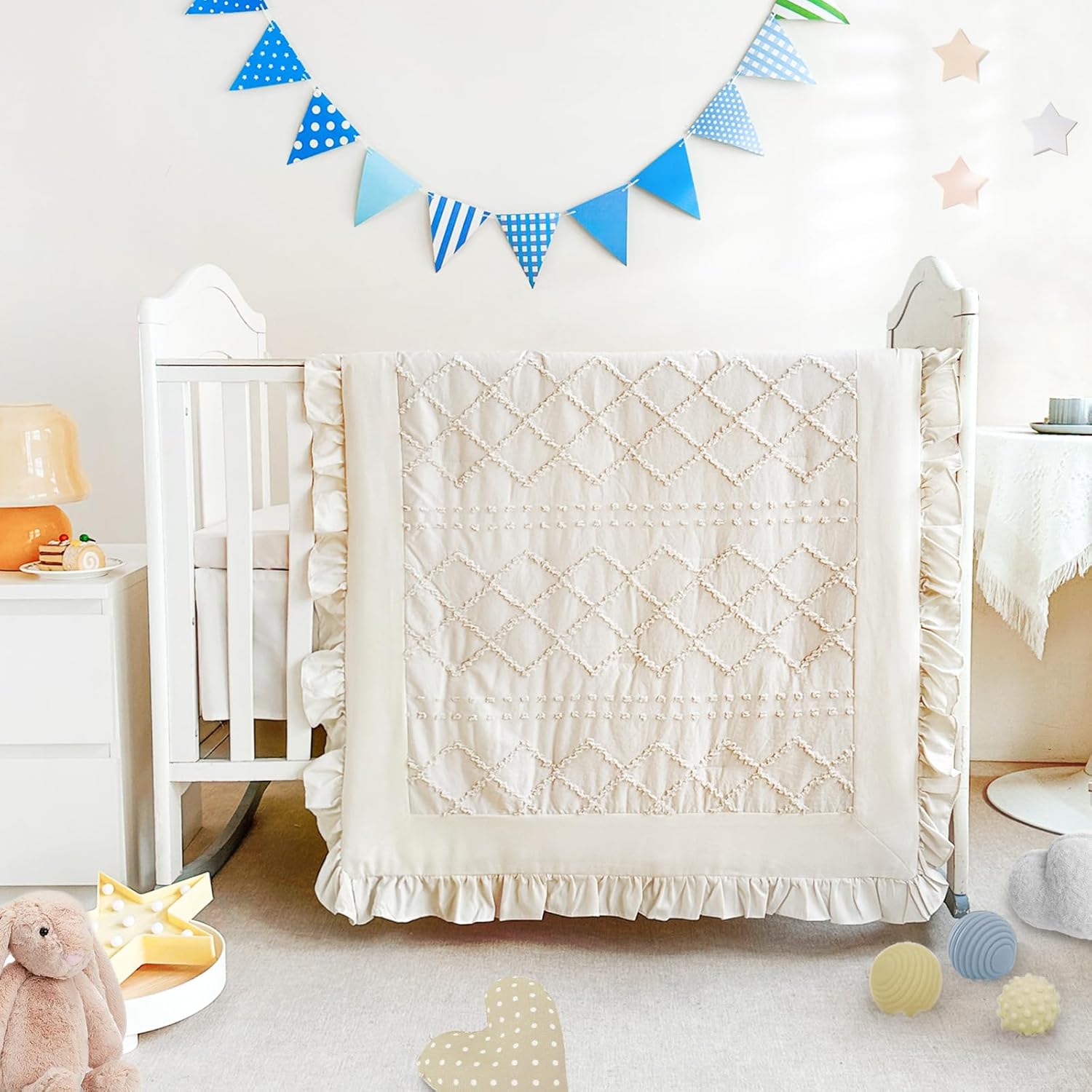 Wowelife Boho Mini Crib Bedding Set front view featuring beige tufted jacquard comforter and ruffled skirt inside a nursery crib.