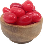 Oversized sweet and spicy red cinnamon candies used as decorative toppings on holiday desserts.