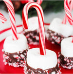 Kandyrifik mini candy canes being used as a garnish for a hot chocolate mug.