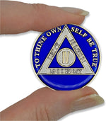 Close up of 24 karat gold and silver plating on sobriety medallion