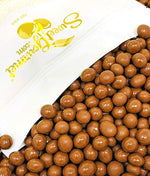 Premium milk chocolate espresso beans poured into a white serving bowl