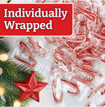 Individually wrapped red and white striped peppermint candy canes arranged on a table.