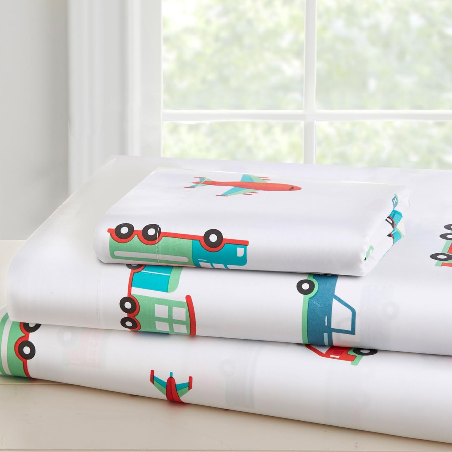 Wildkin toddler sheet set front view featuring colorful transportation pattern on white bedding.