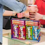 Movie night setup featuring assorted Skittles and Starburst full size packs